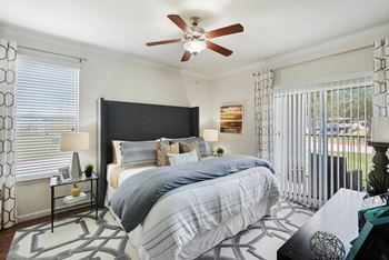 A bedroom with a bed and a ceiling fan